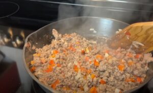 Ground venison meat and bell peppers sizzling in a skillet