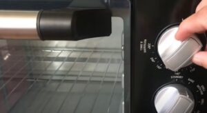 Adjusting the temperature control on a rotisserie and grill appliance