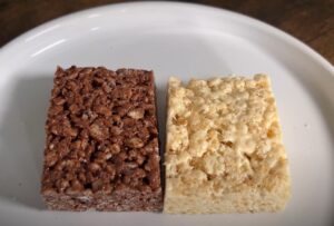 Two squares of rice crispy treats, one chocolate and one vanilla